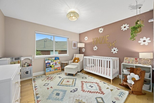 3703 Runnels Ct, Austin, TX 78732 - bedroom with light wood-style flooring and a crib