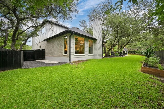 3703 Runnels Ct, Austin, TX 78732 - back of property featuring a chimney, a garden, and brick siding