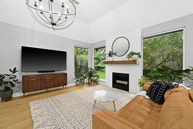 3703 Runnels Ct, Austin, TX 78732 - living area with wood finished floors, a chandelier, a large fireplace, and lofted ceiling
