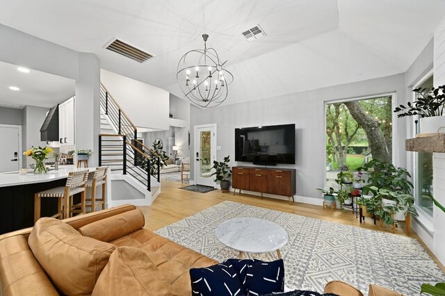 3703 Runnels Ct, Austin, TX 78732 - living room featuring light wood-style flooring, a chandelier, stairway, and lofted ceiling