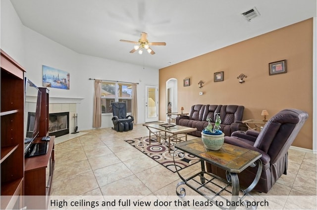 118 Lone Star Blvd, Hutto, TX 78634 - living room featuring a ceiling fan, a tile fireplace, arched walkways, and light tile patterned flooring