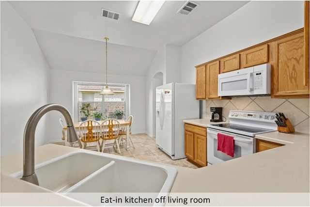 118 Lone Star Blvd, Hutto, TX 78634 - kitchen with white appliances, backsplash, vaulted ceiling, decorative light fixtures, and light countertops
