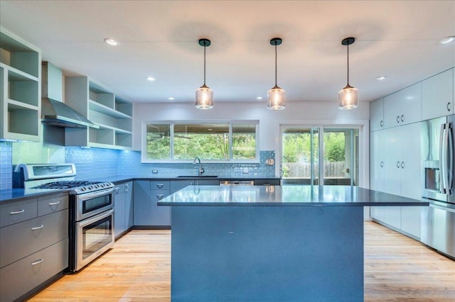 6602 Daugherty St, Austin, TX 78757 - kitchen featuring stainless steel appliances, dark countertops, open shelves, light wood finished floors, and recessed lighting