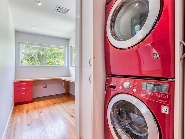 6602 Daugherty St, Austin, TX 78757 - washroom with stacked washing machine and dryer, light wood-style floors, an office area, and recessed lighting