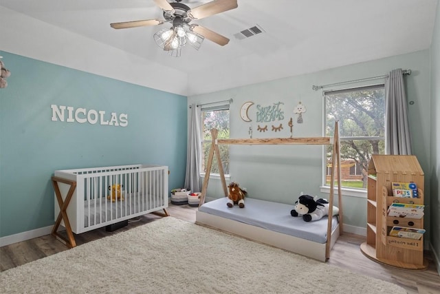 2108 Ariella Dr, Cedar Park, TX 78613 - bedroom with wood finished floors, multiple windows, a nursery area, and ceiling fan