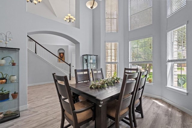 2108 Ariella Dr, Cedar Park, TX 78613 - dining space featuring arched walkways, a high ceiling, healthy amount of natural light, light wood-style floors, and stairs