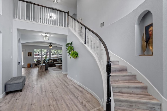 2108 Ariella Dr, Cedar Park, TX 78613 - staircase featuring a towering ceiling, wood finished floors, arched walkways, and a ceiling fan