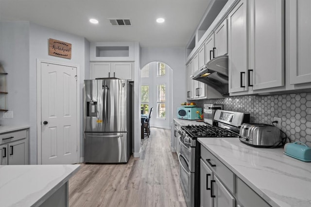 2108 Ariella Dr, Cedar Park, TX 78613 - kitchen with stainless steel appliances, extractor fan, light wood-style flooring, light stone counters, and tasteful backsplash
