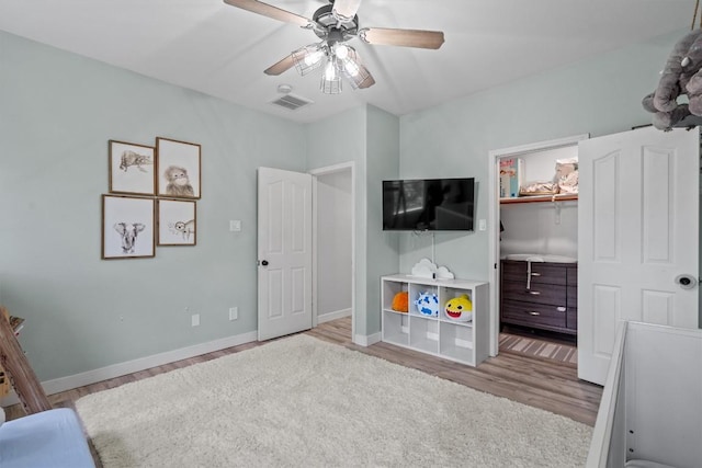 2108 Ariella Dr, Cedar Park, TX 78613 - bedroom with wood finished floors, a spacious closet, and ceiling fan