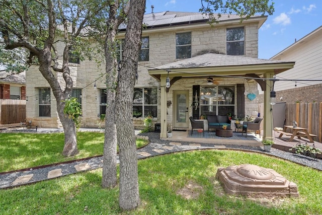 2108 Ariella Dr, Cedar Park, TX 78613 - back of property with a ceiling fan, outdoor lounge area, solar panels, stone siding, and a patio