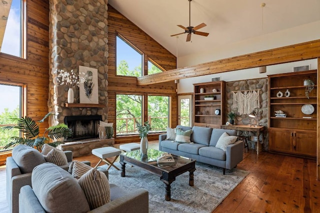 8152 Breeze Way, Jonestown, TX 78645 - living room featuring high vaulted ceiling, wood-type flooring, ceiling fan, a fireplace, and wood walls