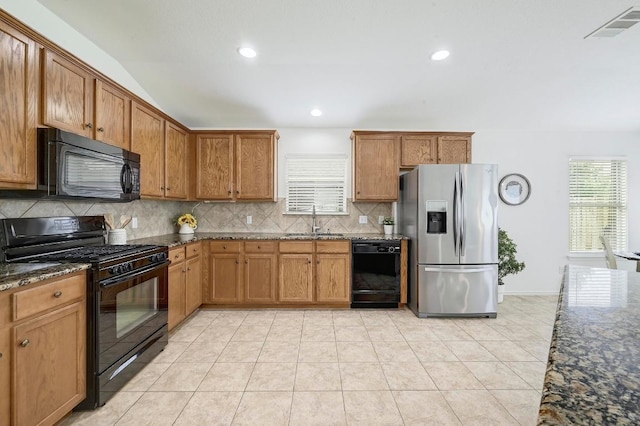 20209 Harrier Flight Trl, Pflugerville, TX 78660 - kitchen with black appliances, decorative backsplash, dark stone counters, brown cabinets, and recessed lighting