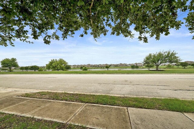 20209 Harrier Flight Trl, Pflugerville, TX 78660 - view of asphalt road featuring sidewalks and curbs