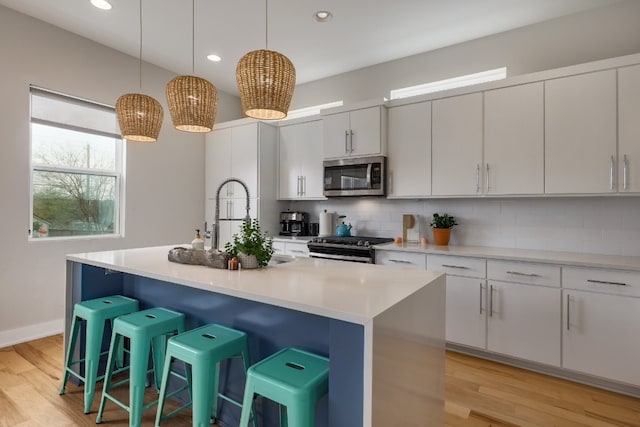 7013 Boyle Dr, Austin, TX 78724 - kitchen with stainless steel appliances, backsplash, light wood finished floors, a breakfast bar, and light countertops