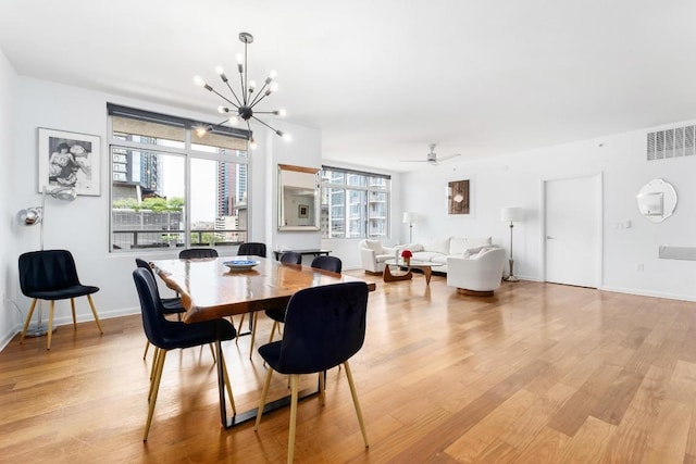 54 Rainey St Unit 1018, Austin, TX 78701 - dining space featuring a chandelier, light wood-style floors, and a ceiling fan