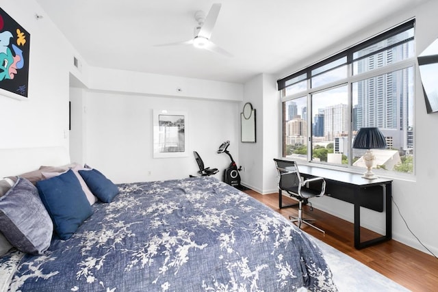 54 Rainey St Unit 1018, Austin, TX 78701 - bedroom featuring wood finished floors, a desk, and ceiling fan