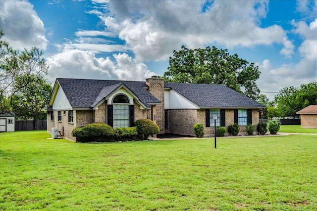 206 Live Oak Dr, Mountain City, TX 78610 - view of front of home featuring a shed, a chimney, brick siding, and roof with shingles