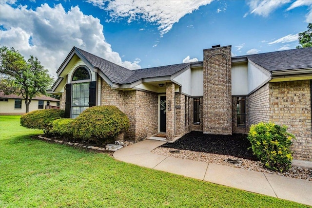 206 Live Oak Dr, Mountain City, TX 78610 - view of front facade featuring a front lawn, a chimney, brick siding, and roof with shingles