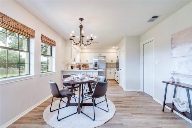 206 Live Oak Dr, Mountain City, TX 78610 - dining room with a chandelier and light wood-style floors