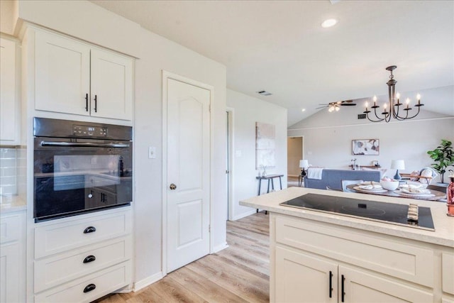 206 Live Oak Dr, Mountain City, TX 78610 - kitchen featuring black appliances, light wood finished floors, light countertops, white cabinetry, and a chandelier