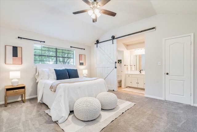 206 Live Oak Dr, Mountain City, TX 78610 - bedroom featuring a barn door, vaulted ceiling, light carpet, ensuite bathroom, and ceiling fan