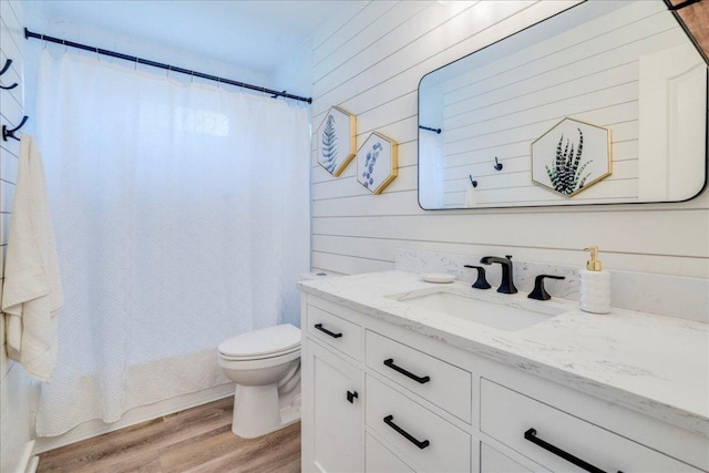 206 Live Oak Dr, Mountain City, TX 78610 - bathroom featuring vanity, wood finished floors, wood walls, and shower / bathtub combination with curtain