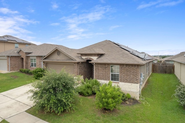 15212 Shell Bark Cv, Austin, TX 78724 - view of front of house featuring brick siding, an attached garage, roof mounted solar panels, a shingled roof, and concrete driveway