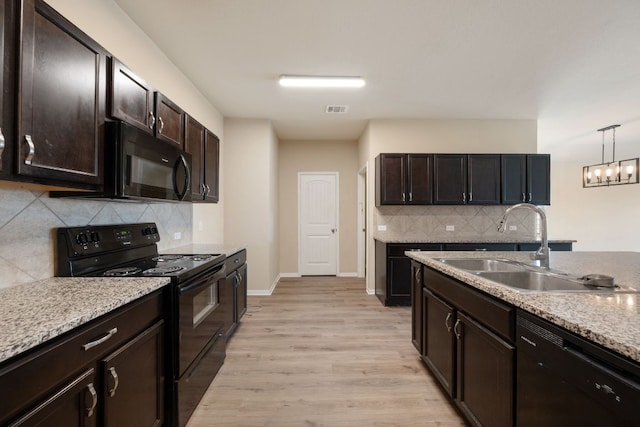15212 Shell Bark Cv, Austin, TX 78724 - kitchen with black appliances, backsplash, light wood-style floors, and dark brown cabinets