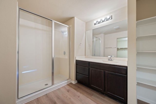15212 Shell Bark Cv, Austin, TX 78724 - full bath featuring wood finished floors, a stall shower, a walk in closet, and vanity