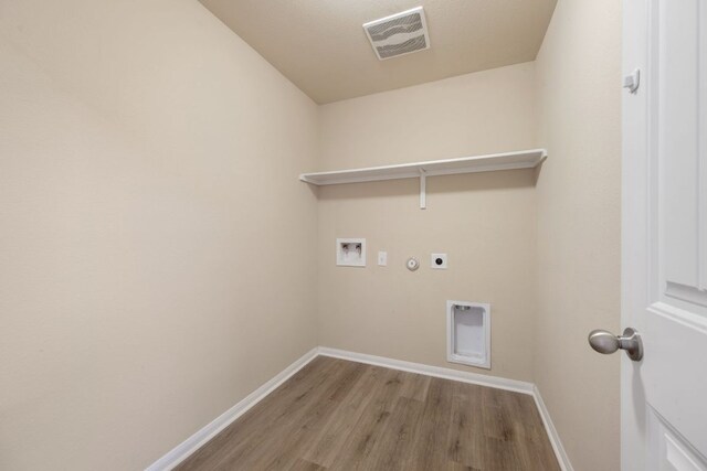 15212 Shell Bark Cv, Austin, TX 78724 - laundry room featuring hookup for an electric dryer, wood finished floors, hookup for a washing machine, and hookup for a gas dryer
