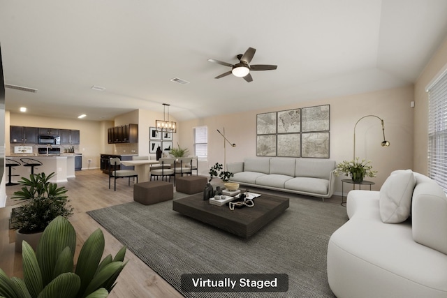 15212 Shell Bark Cv, Austin, TX 78724 - living area featuring light wood-type flooring, a ceiling fan, and healthy amount of natural light