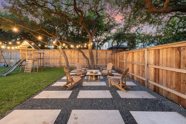 10408 Hansa Dr, Austin, TX 78739 - patio terrace at dusk with an outdoor fire pit, a playground, a fenced backyard, and a patio area