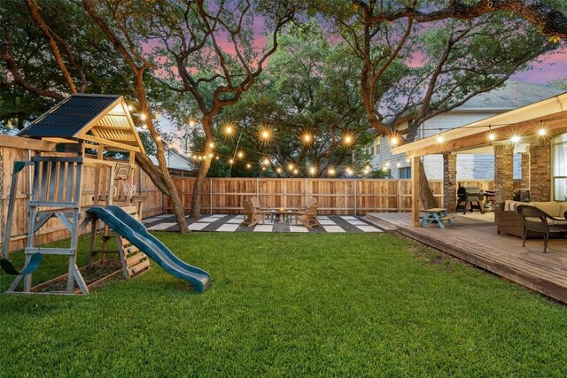 10408 Hansa Dr, Austin, TX 78739 - yard at dusk featuring a playground, a fenced backyard, and a wooden deck