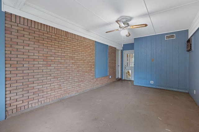 10000 Gail Rd, Austin, TX 78748 - spare room with concrete floors, a ceiling fan, brick wall, and wooden walls
