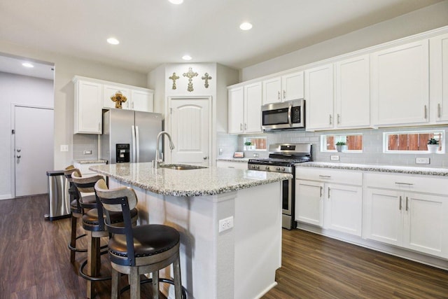 16601 Aventura Ave, Pflugerville, TX 78660 - kitchen featuring appliances with stainless steel finishes, white cabinetry, a breakfast bar area, and recessed lighting