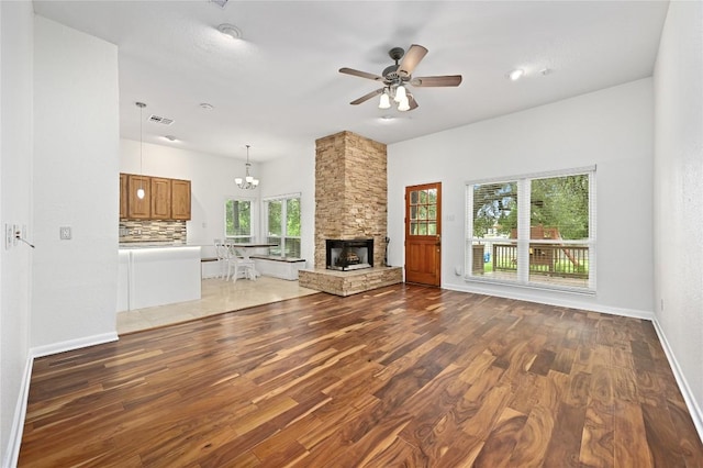 301 Crane St, Austin, TX 78734 - unfurnished living room with wood finished floors, a chandelier, a ceiling fan, and a fireplace