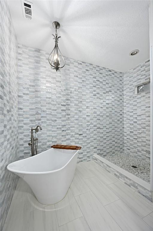 301 Crane St, Austin, TX 78734 - bathroom featuring a soaking tub and tile walls
