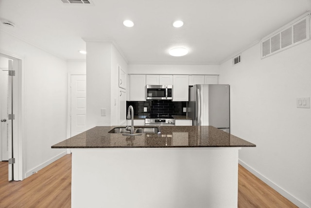8888 Tallwood Dr Unit 1202, Austin, TX 78759 - kitchen featuring appliances with stainless steel finishes, light wood-style floors, white cabinets, decorative backsplash, and ornamental molding