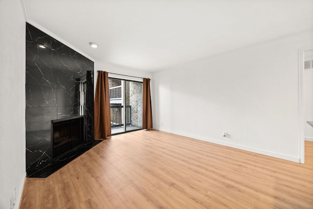 8888 Tallwood Dr Unit 1202, Austin, TX 78759 - unfurnished living room featuring wood finished floors, a fireplace, and crown molding