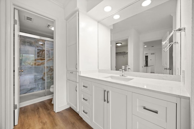 8888 Tallwood Dr Unit 1202, Austin, TX 78759 - full bathroom featuring a stall shower, vanity, wood finished floors, ornamental molding, and recessed lighting