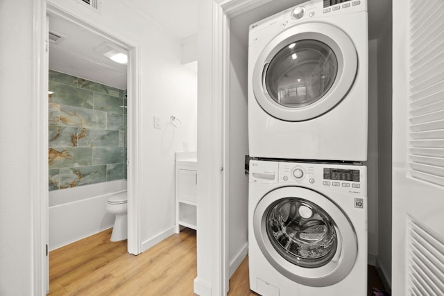 8888 Tallwood Dr Unit 1202, Austin, TX 78759 - washroom with stacked washing machine and dryer and light wood-style flooring
