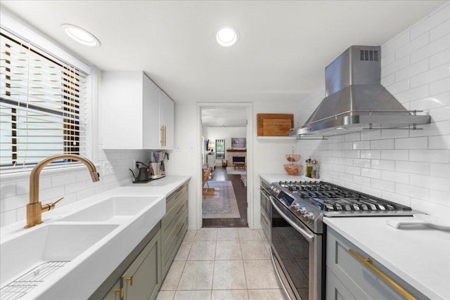 2616 Jefferson St Unit A, Austin, TX 78703 - kitchen with ventilation hood, stainless steel range with gas stovetop, gray cabinets, backsplash, and recessed lighting