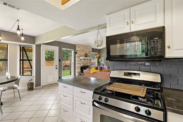 809 Windsor Rd, Round Rock, TX 78664 - kitchen featuring stainless steel gas range, black microwave, dark countertops, light tile patterned floors, and white cabinetry