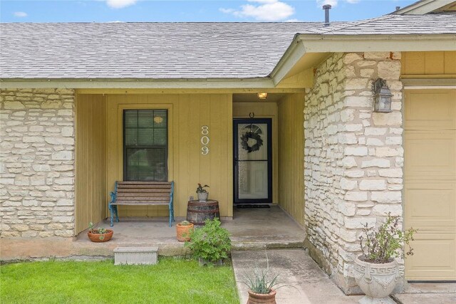 809 Windsor Rd, Round Rock, TX 78664 - property entrance featuring a shingled roof, stone siding, and a garage