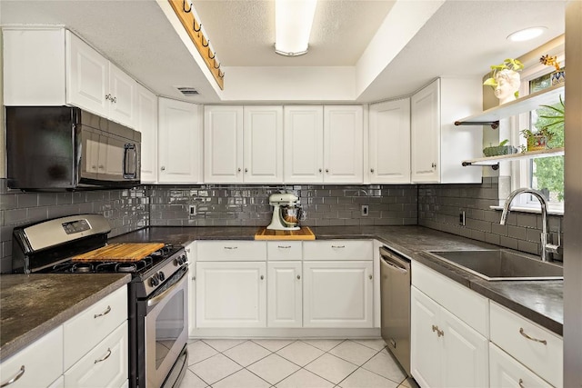 809 Windsor Rd, Round Rock, TX 78664 - kitchen with appliances with stainless steel finishes, open shelves, dark countertops, white cabinets, and a textured ceiling