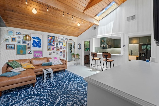 11302 Centennial Trl, Austin, TX 78726 - carpeted living room featuring vaulted ceiling, a skylight, wooden ceiling, arched walkways, and track lighting