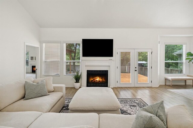 2901 Rochelle Dr, Austin, TX 78748 - living room with a warm lit fireplace, wood finished floors, and french doors