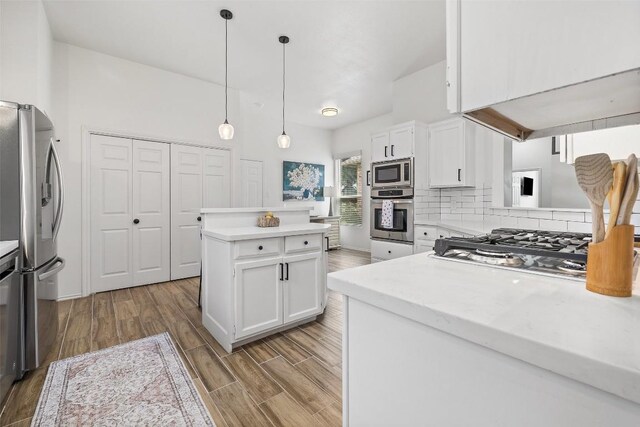 2901 Rochelle Dr, Austin, TX 78748 - kitchen with appliances with stainless steel finishes, a center island, light wood-style flooring, decorative backsplash, and white cabinets