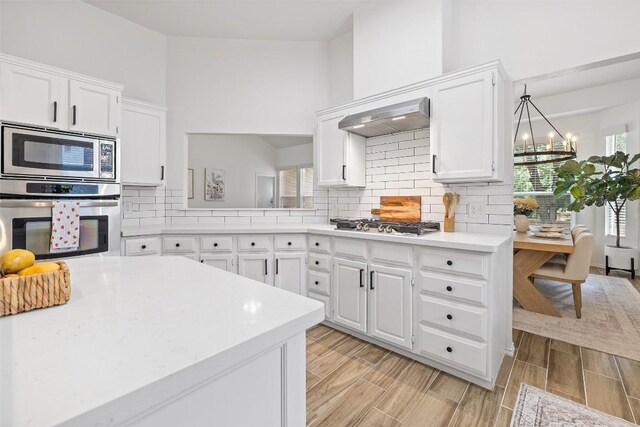 2901 Rochelle Dr, Austin, TX 78748 - kitchen with appliances with stainless steel finishes, light countertops, white cabinets, backsplash, and wood finish floors