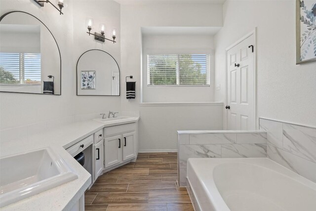 2901 Rochelle Dr, Austin, TX 78748 - bathroom featuring vanity, a garden tub, and wood finished floors